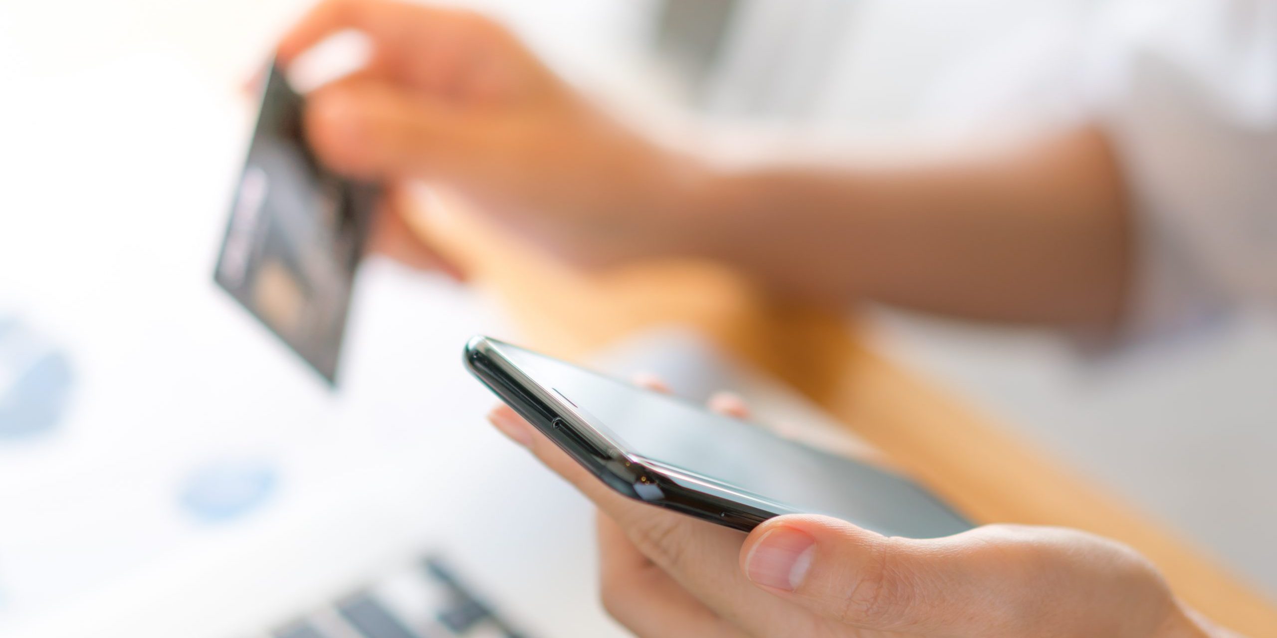 Hands holding a credit card using laptop computer and mobile pho