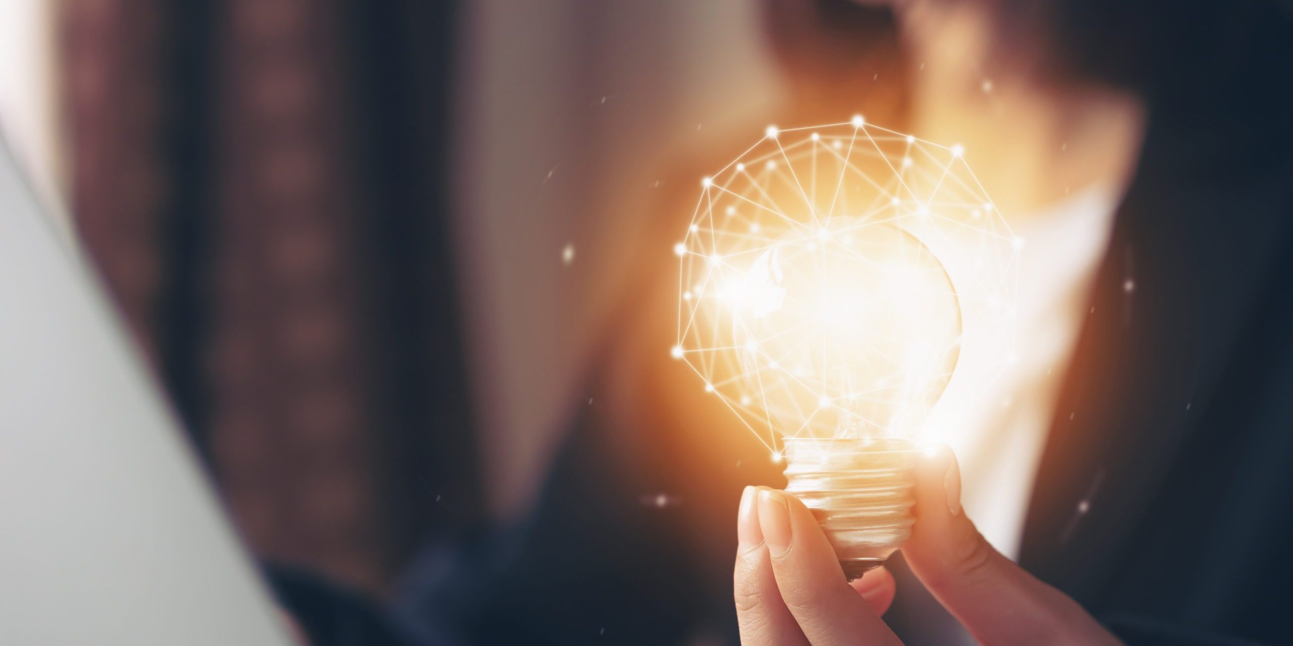 Hand holding light bulb with innovative and creativity are keys to success. Concept knowledge leads to ideas and inspiration.