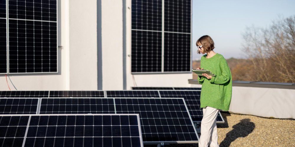 Mujer en azotea con tableta y placas solares