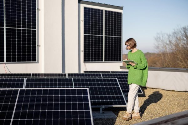 Mujer en azotea con tableta y placas solares